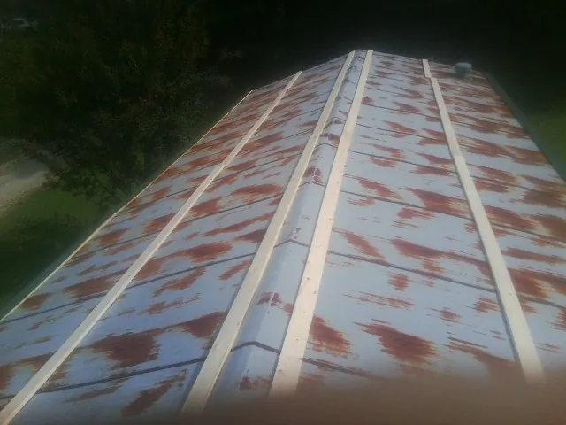 Rusted metal roof panels with new wood purlins before replacement — Storm Damage Roof Repair in Washington Grove by Roofing Brothers