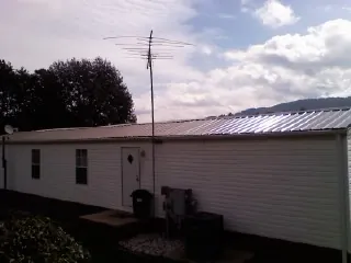 New metal roof on a single wide mobile home with a TV antenna in Washington Grove