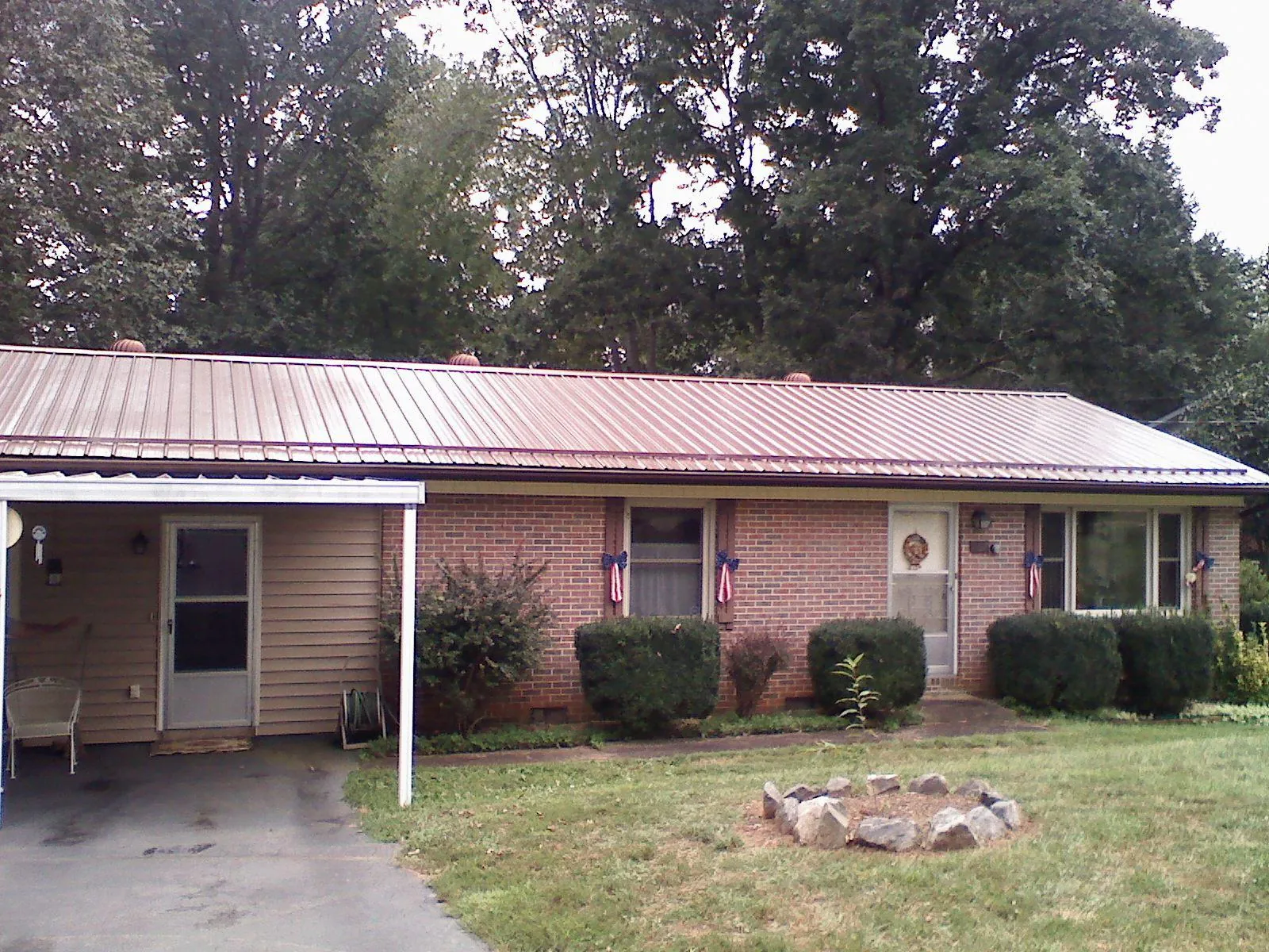Bronze metal roof and carport on a brick ranch home — Roof Repair work by our crew in Washington Grove