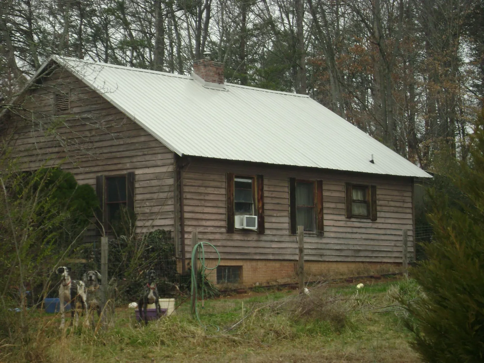 White metal roof on an old wood sided farmhouse, from a Metal Roof Installation job in Washington Grove