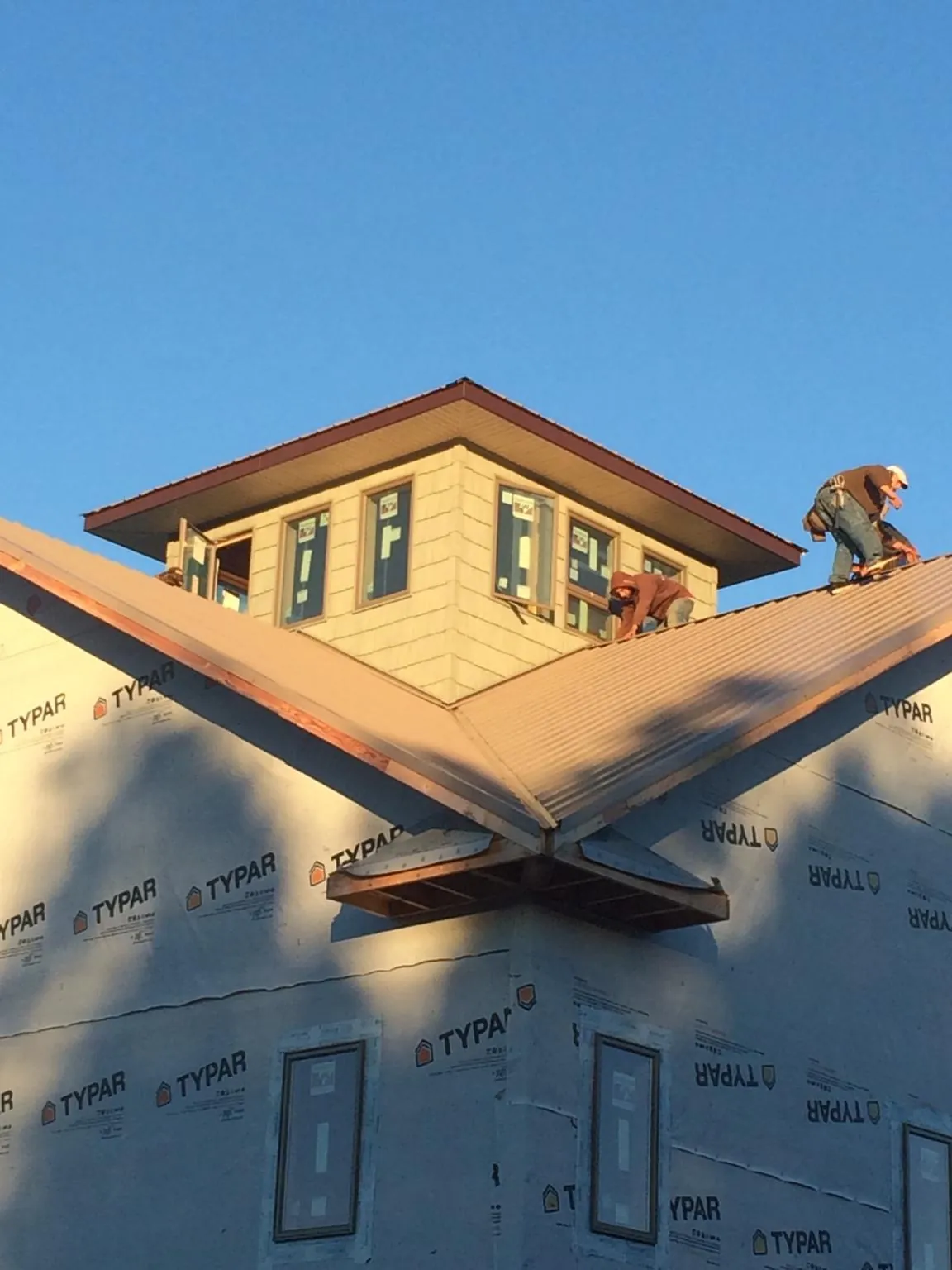 Roofers working around a rooftop cupola on a new metal roof at sunset — Roof Waterproofing in Washington Grove by Roofing Brothers